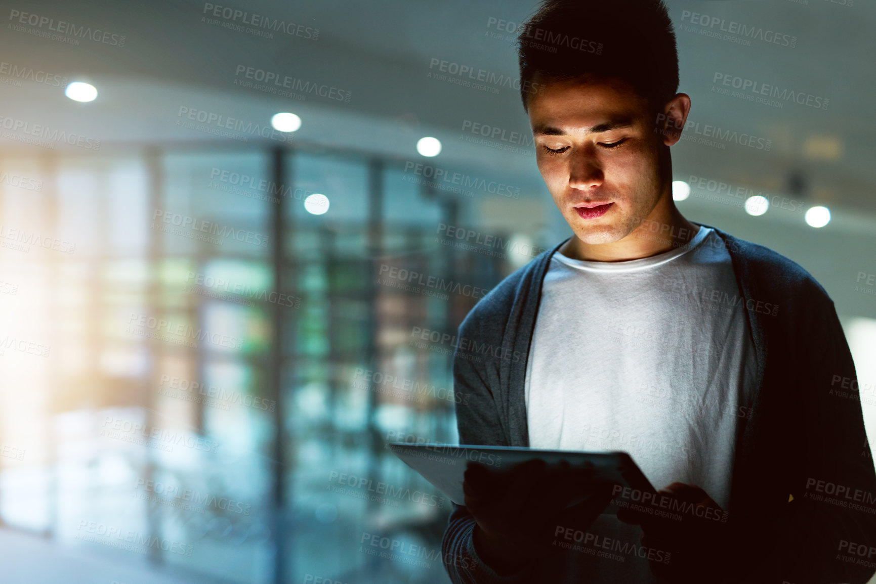 Buy stock photo Shot of a handsome young male programmer working late in his office