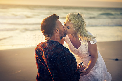 Buy stock photo Kiss, engagement and couple with ring on beach for proposal, celebration and anniversary outdoors. Dating, marriage and man and woman with jewellery for honeymoon, vacation and romantic holiday