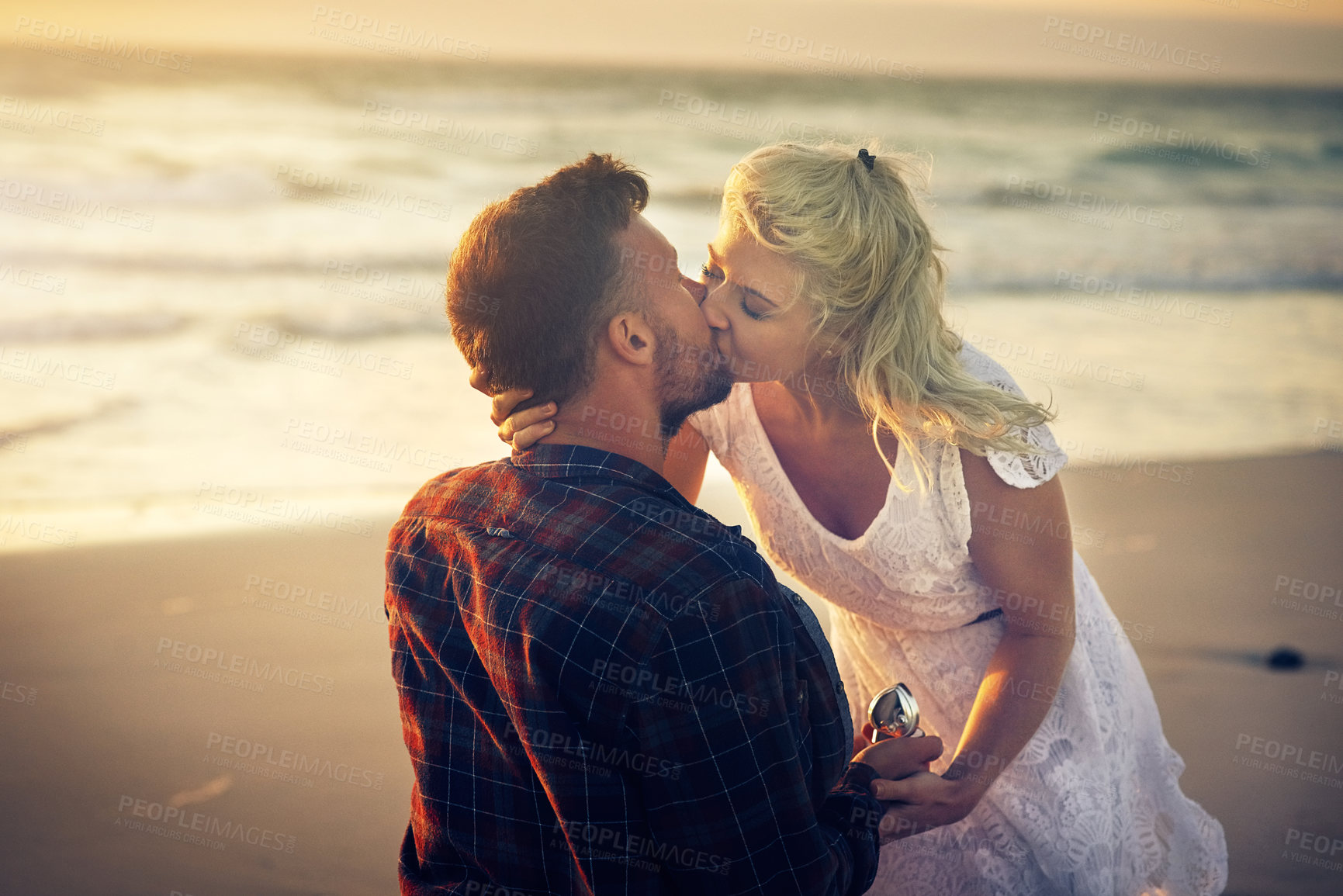 Buy stock photo Kiss, engagement and couple with ring on beach for proposal, celebration and anniversary outdoors. Dating, marriage and man and woman with jewellery for honeymoon, vacation and romantic holiday