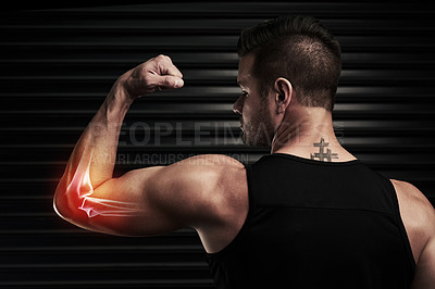 Buy stock photo Rearview shot of an athletic young man flexing with an elbow injury in the studio