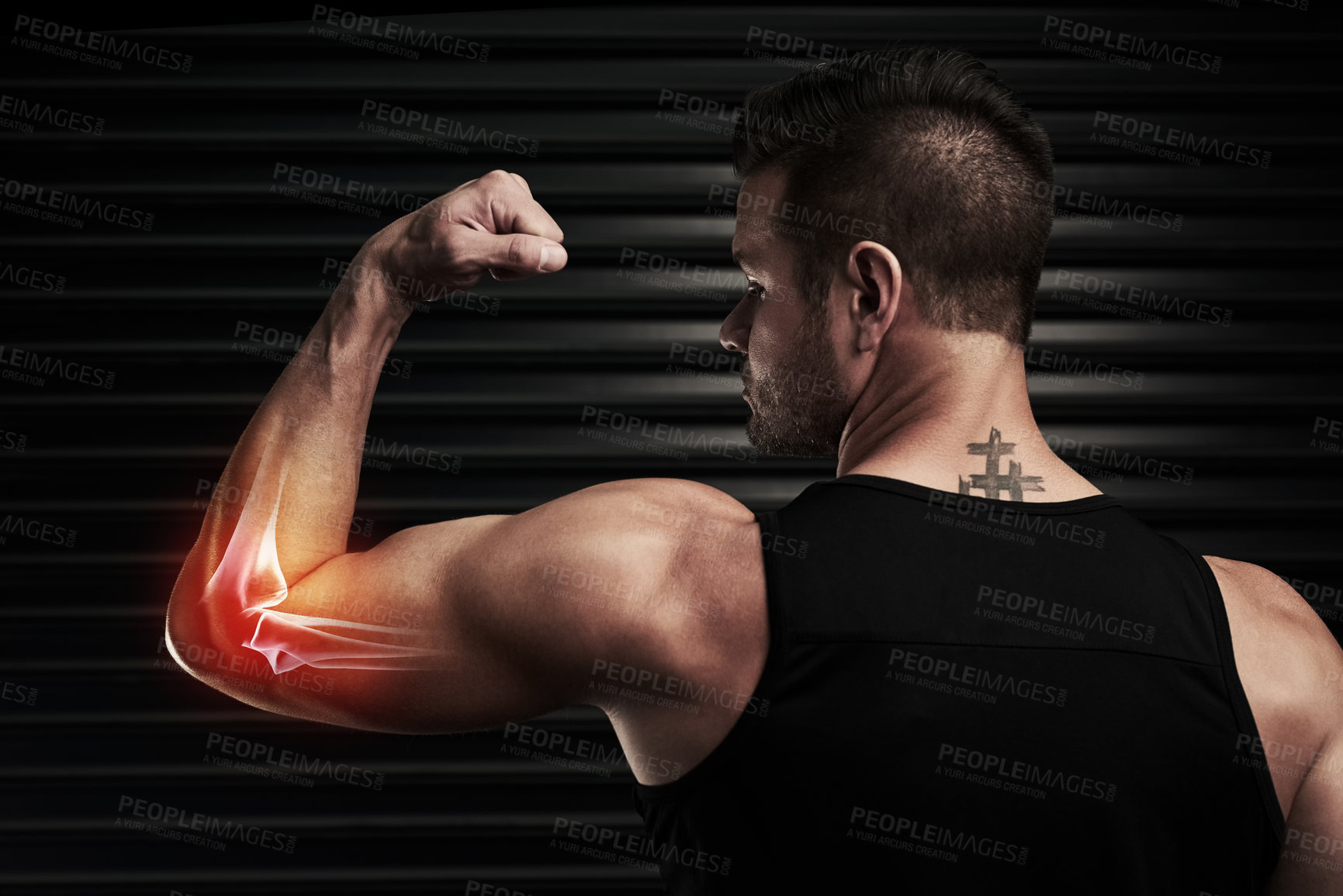 Buy stock photo Rearview shot of an athletic young man flexing with an elbow injury in the studio