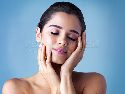 Buy stock photo Skincare, woman and hands on face in studio for wellness, beauty and make up on blue background. Dermatology, hands and female person with eyes closed for skin glow, luxury and spa or salon treatment