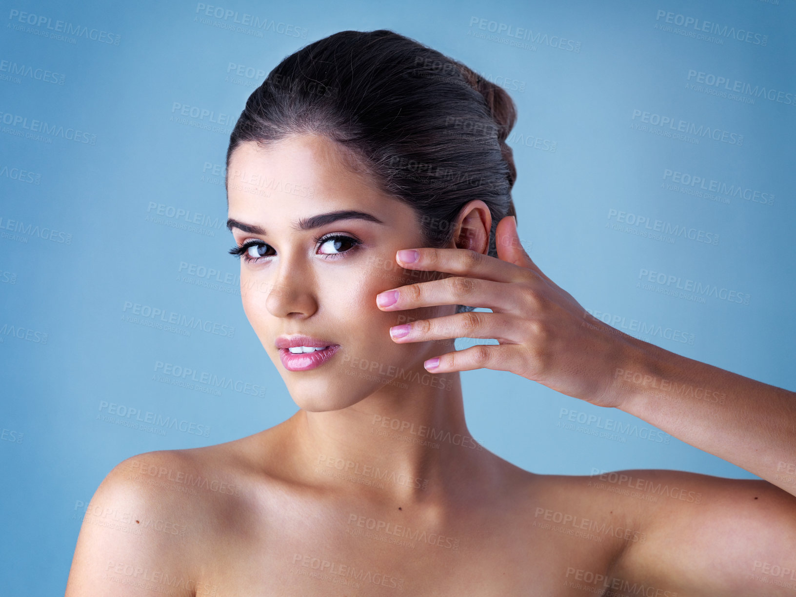 Buy stock photo Studio, portrait and woman with touch, skincare and cosmetics for natural makeup with healthy skin glow. Beauty, dermatology and face of girl with confidence, wellness and care on blue background.