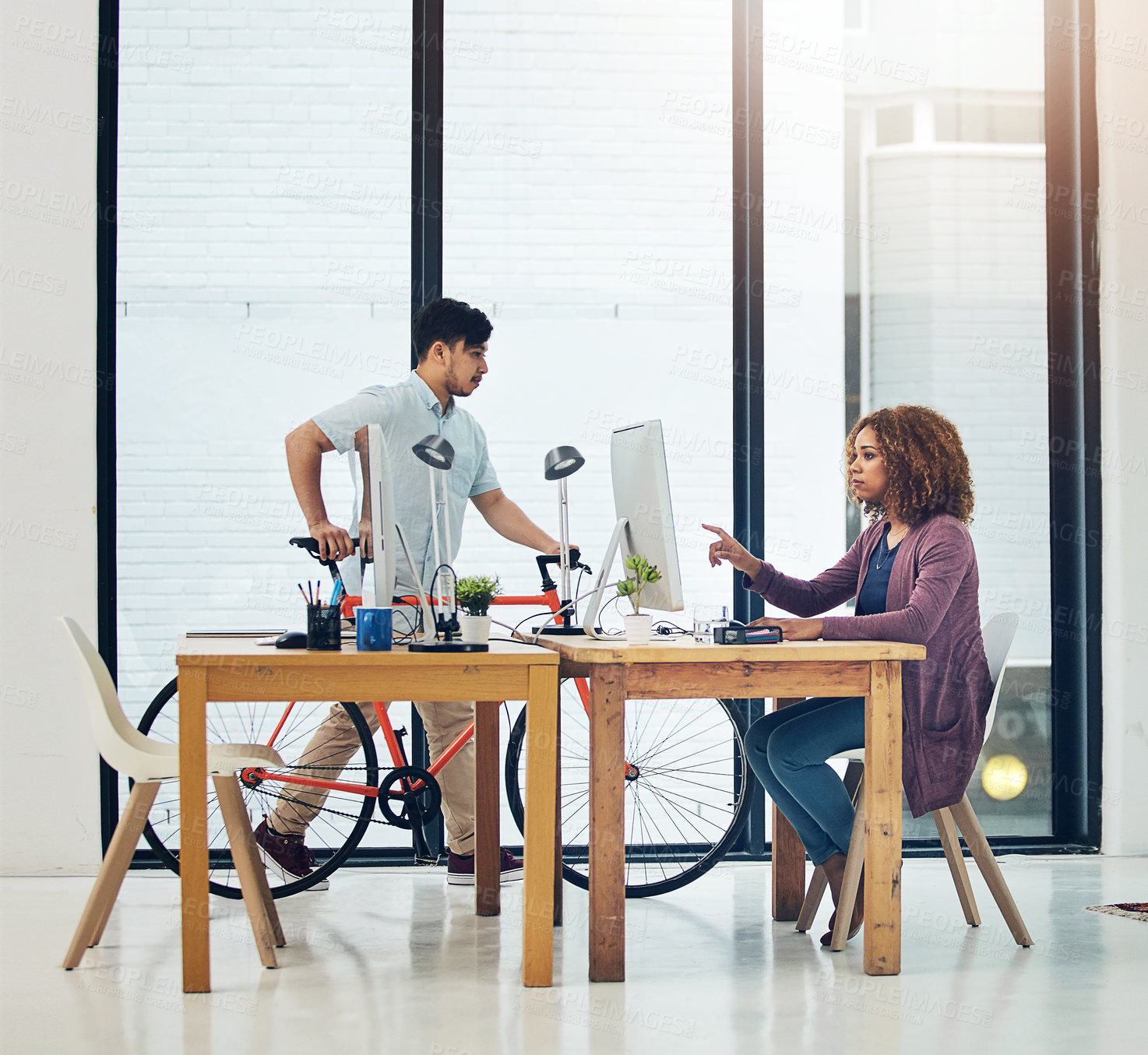 Buy stock photo Shot of two creative colleagues working together in their office