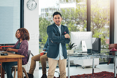 Buy stock photo Portrait of a confident young creative posing in front of his colleagues in the office
