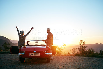 Buy stock photo Shot of a joyful senior couple enjoying the sunset during a roadtrip