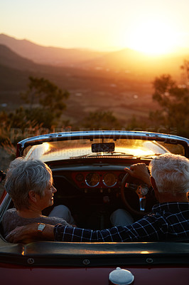 Buy stock photo Shot of an affectionate senior couple enjoying the sunset during a roadtrip