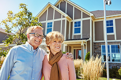 Buy stock photo Shot of a happy senior couple posing outside their new home