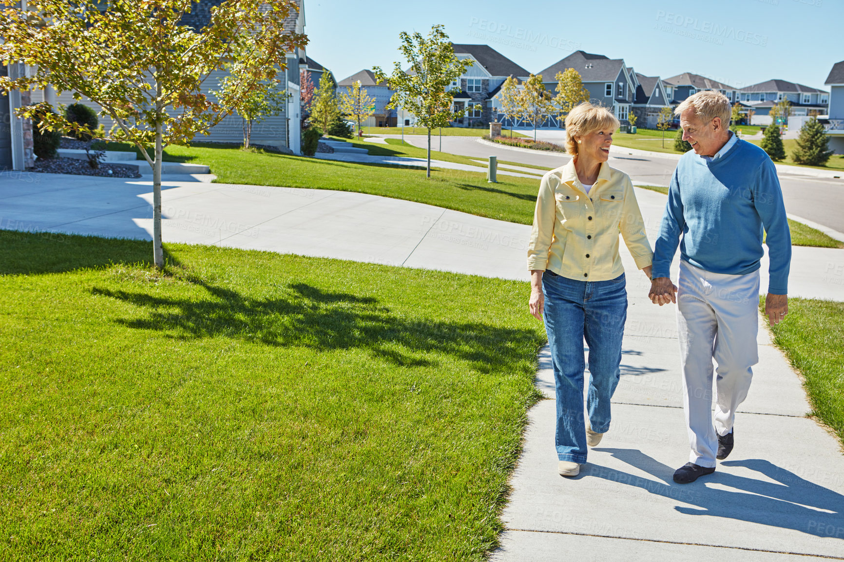 Buy stock photo Shot of a happy senior couple waking around their neighborhood together