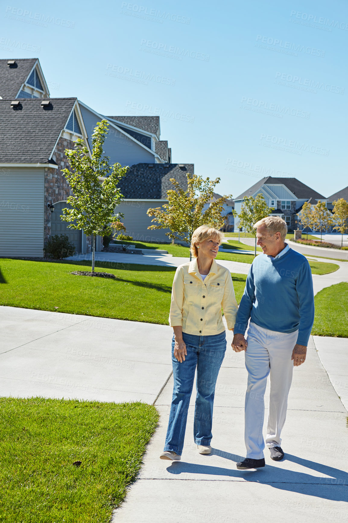 Buy stock photo Shot of a happy senior couple waking around their neighborhood together