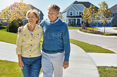 Buy stock photo Shot of a happy senior couple waking around their neighborhood together