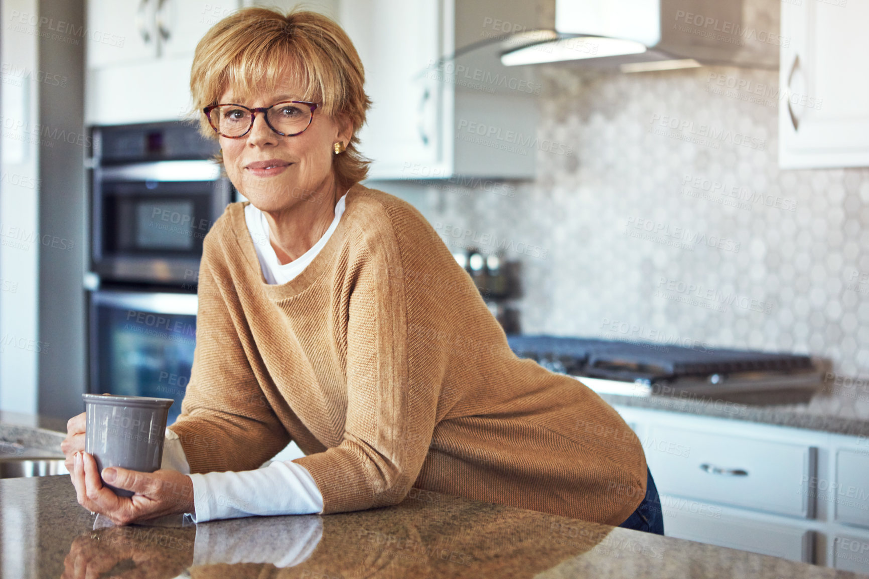 Buy stock photo Cropped portrait of a mature woman drinking coffee in her kitchen