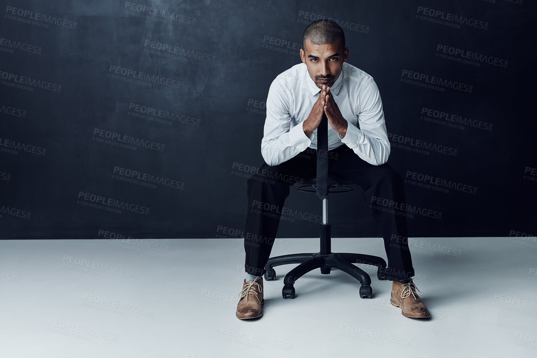 Buy stock photo Studio portrait of a confident young businessman against a dark background