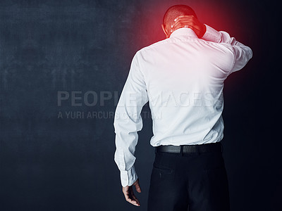 Buy stock photo Studio shot of a young businessman suffering with neck pain highlighted in glowing red