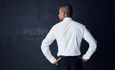 Buy stock photo Rearview studio shot of a young businessman against a dark background