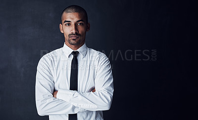 Buy stock photo Studio portrait of a confident young businessman against a dark background