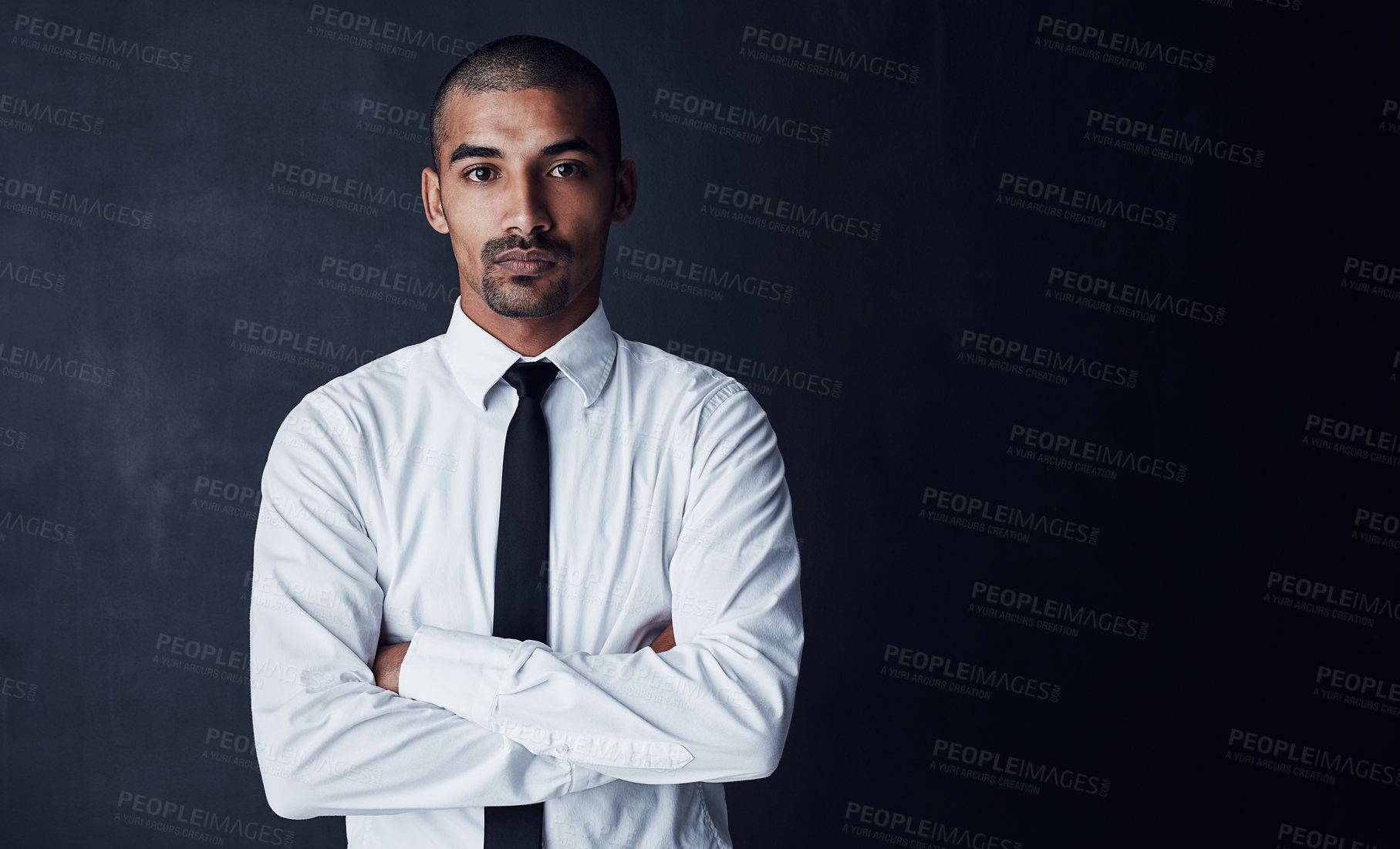 Buy stock photo Studio portrait of a confident young businessman against a dark background