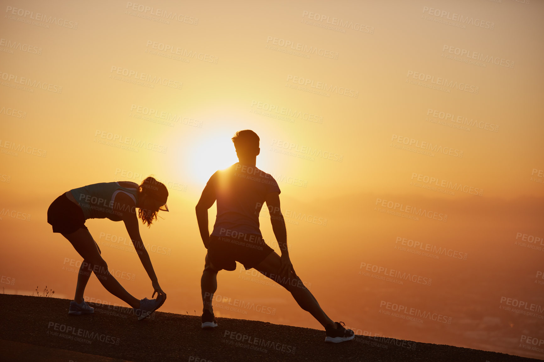 Buy stock photo Shot of a silhouetted couple out for a run at sunrise