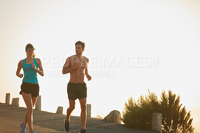 Buy stock photo Shot of an athletic young couple out for a run in the morning