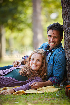 Buy stock photo Shot of a smiling young couple enjoying the day together at the park