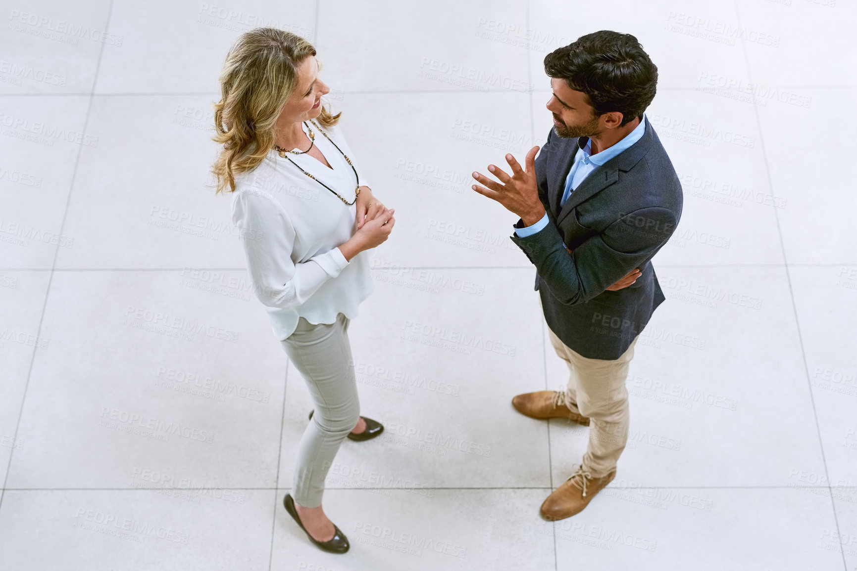 Buy stock photo High angle shot of two businesspeople having a discussion in an office