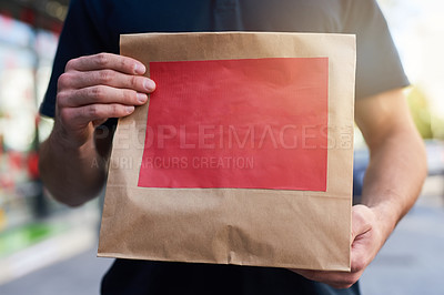 Buy stock photo Cropped shot of a man holding a paper bag for delivery