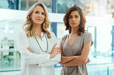 Buy stock photo Portrait of two businesswomen looking serious while posing in an office