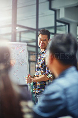 Buy stock photo Shot of a young designer giving a presentation to his colleagues in an office