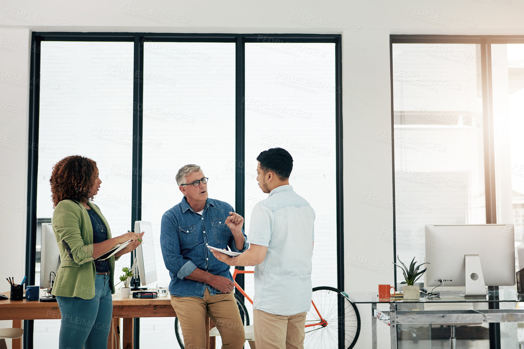 Buy stock photo Cropped shot of three creative professionals talking in the office