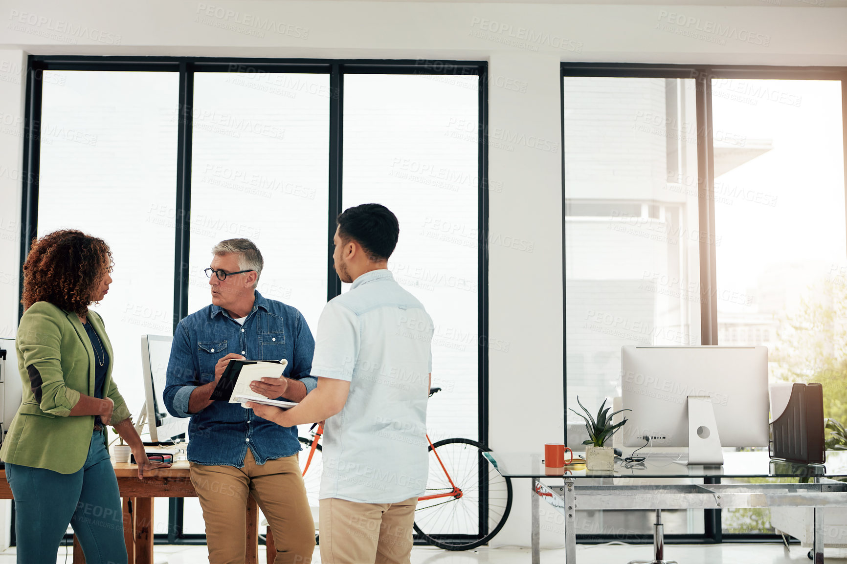 Buy stock photo Cropped shot of three creative professionals talking in the office