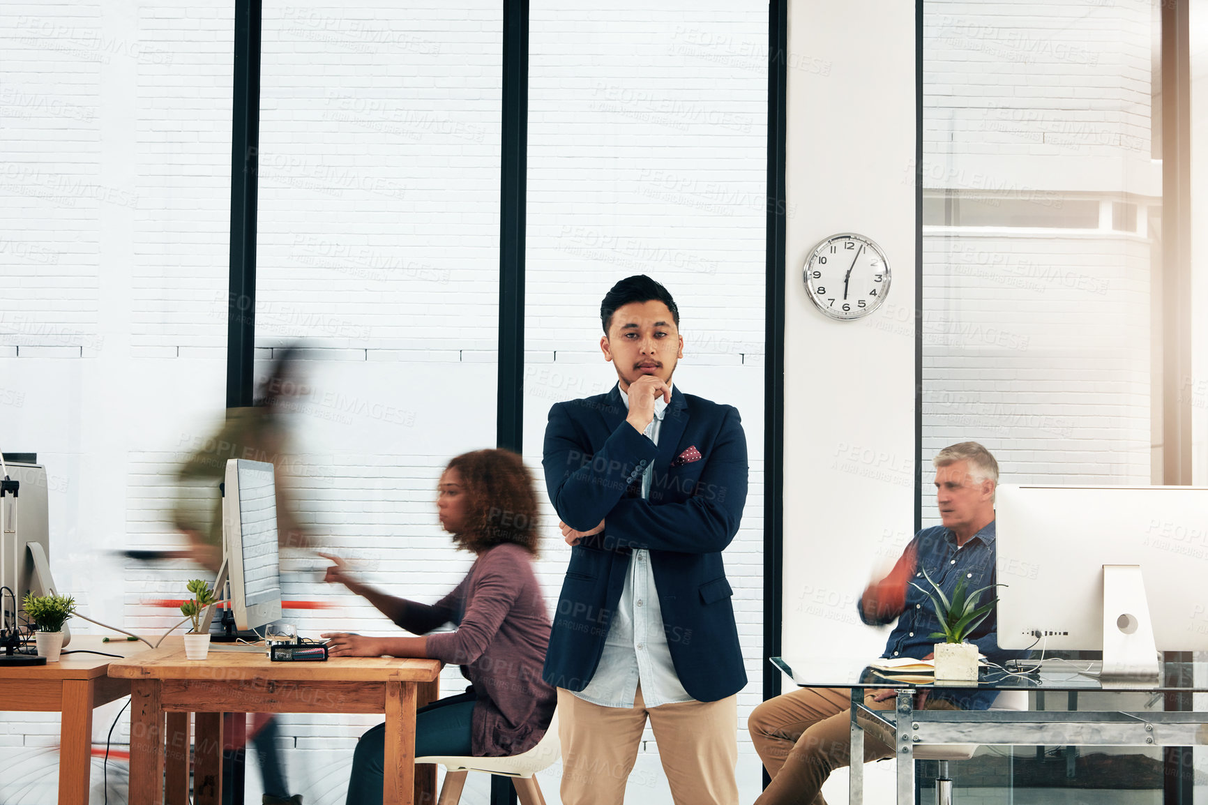 Buy stock photo Portrait of a young designer standing in the office with his colleagues in the background