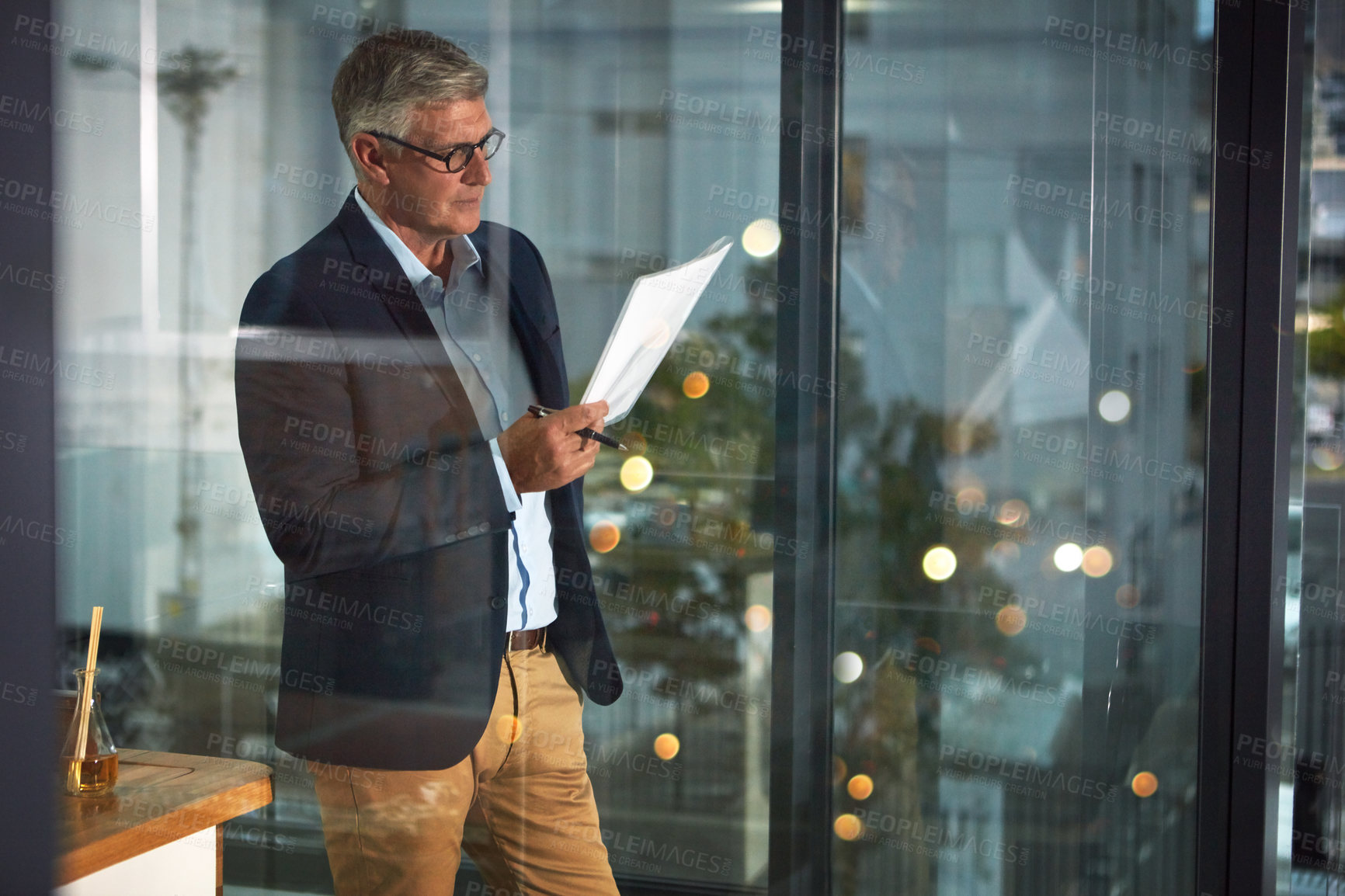 Buy stock photo Shot of a dedicated businessman working alone in his office after hours