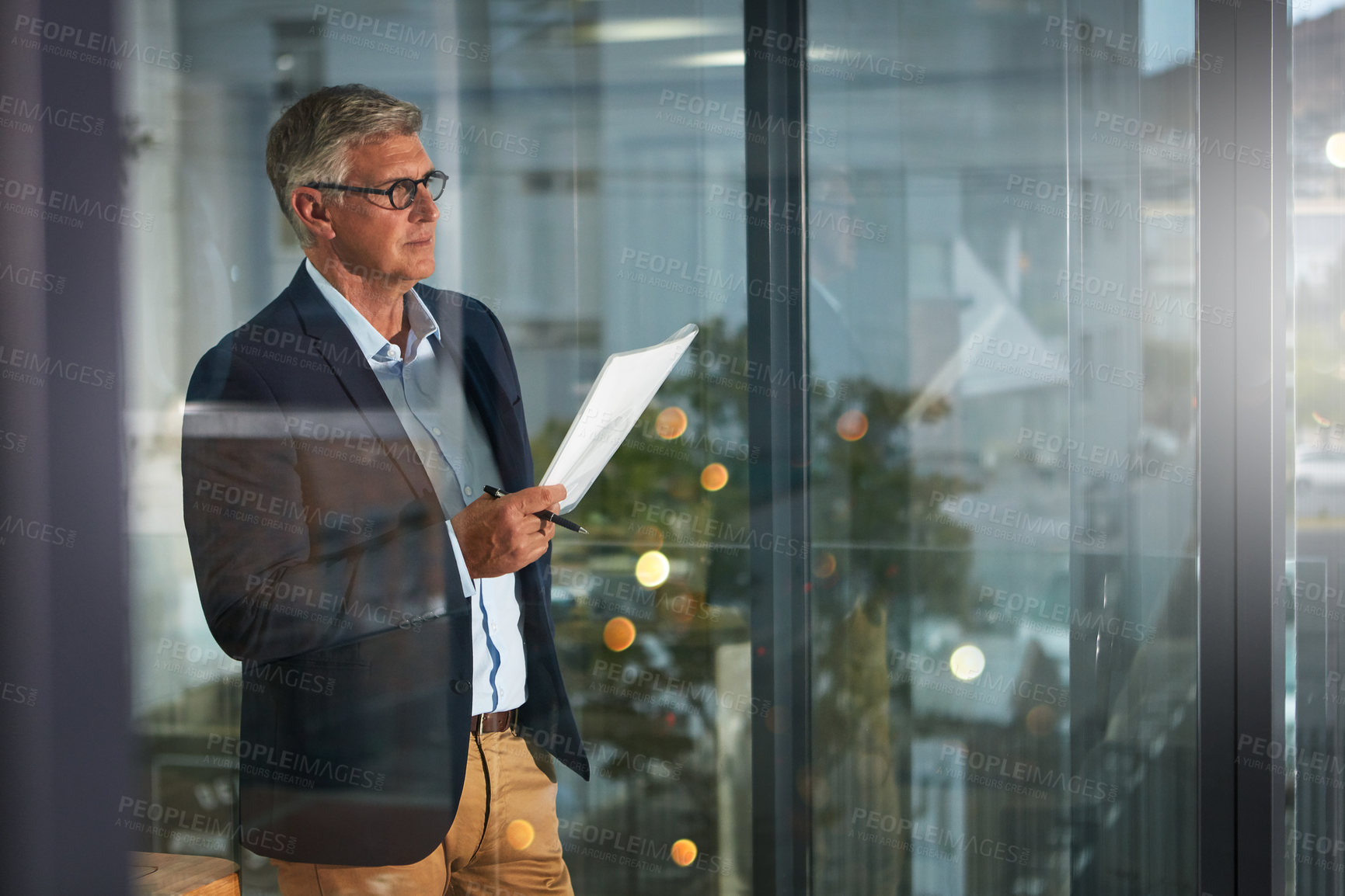 Buy stock photo Shot of a dedicated businessman working alone in his office after hours