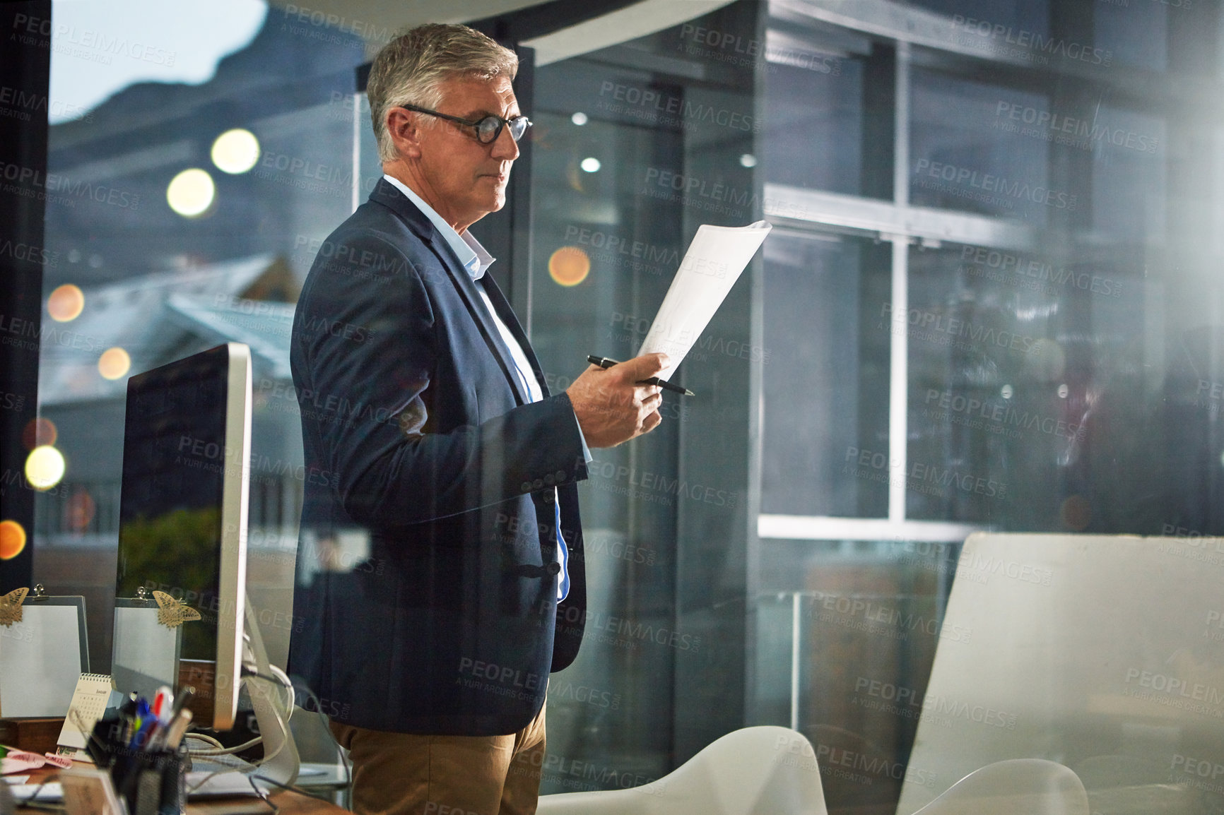 Buy stock photo Shot of a dedicated businessman working alone in his office after hours