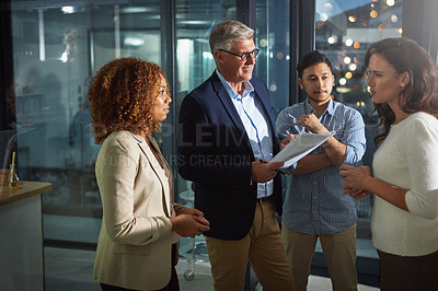 Buy stock photo Shot of a team of dedicated colleagues working together in their office after hours