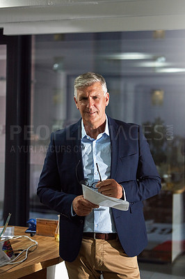 Buy stock photo Portrait of a dedicated businessman working alone in his office after hours