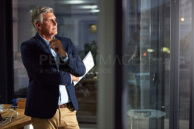 Buy stock photo Shot of a dedicated businessman working alone in his office after hours