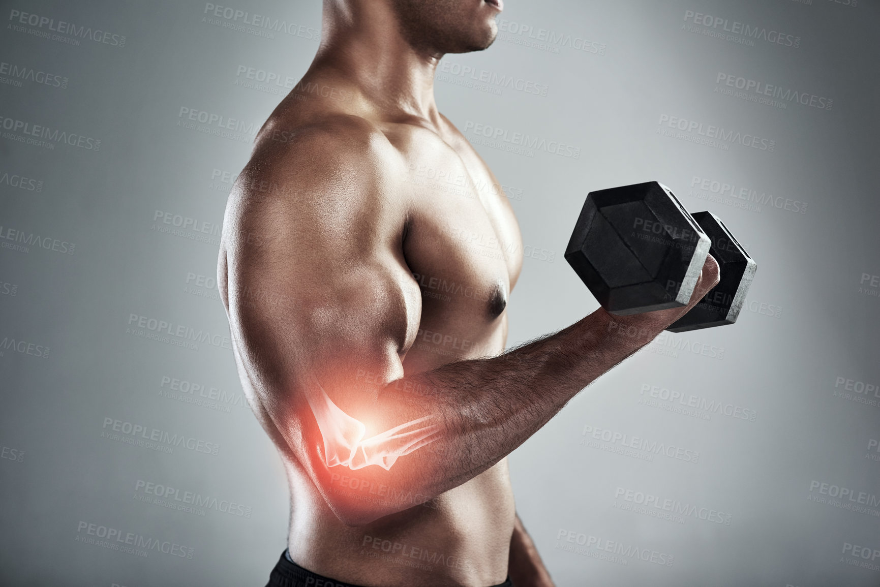 Buy stock photo Shot of a sporty young man working out with a dumbbell against a grey background