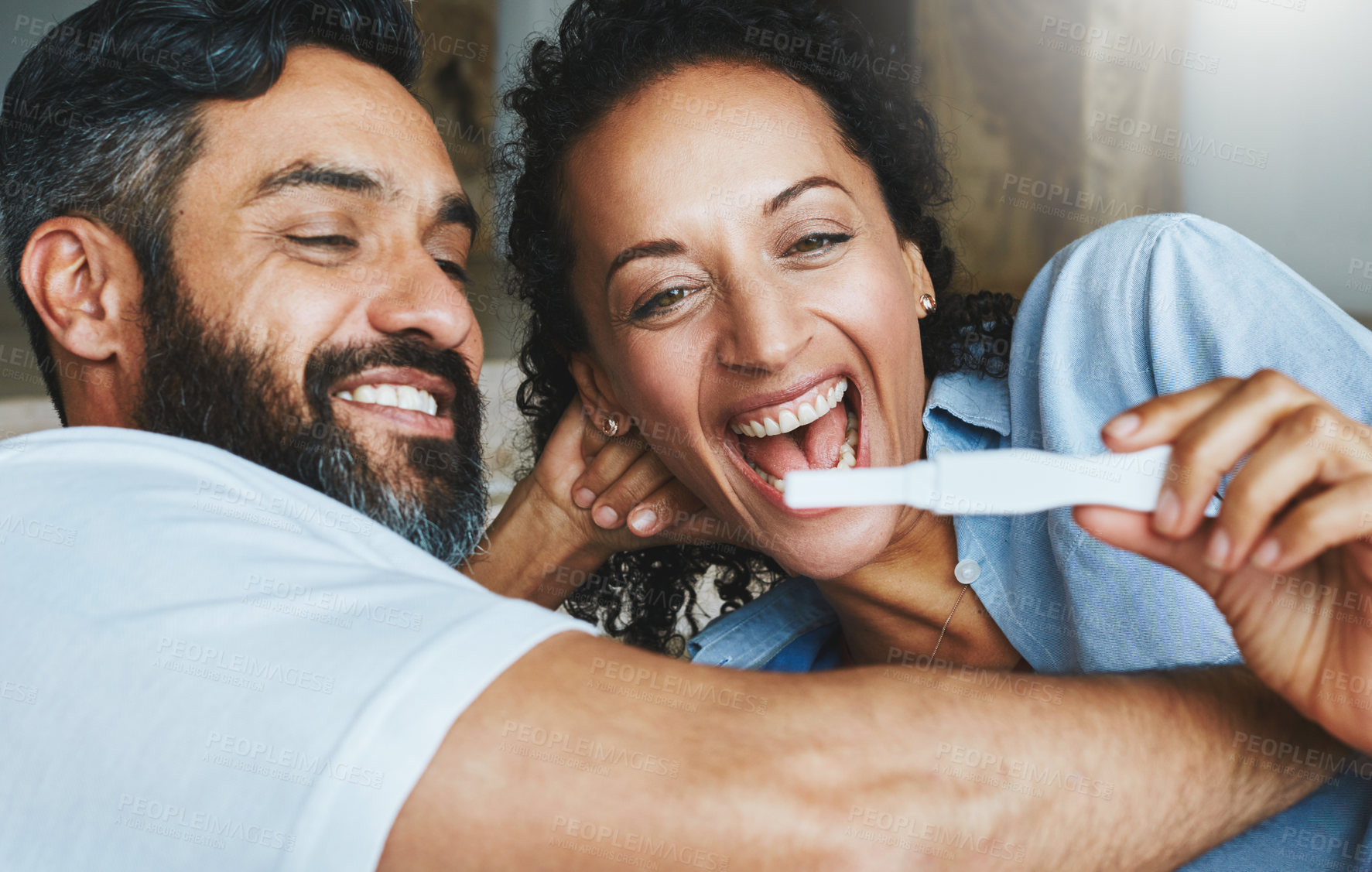 Buy stock photo Shot of a happy couple celebrating their new pregnancy at home together