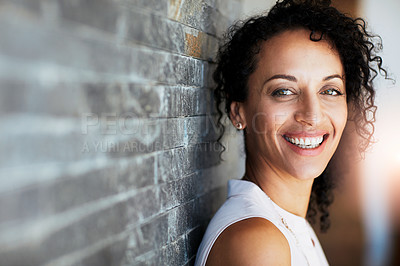 Buy stock photo Portrait of a happy woman posing against a brick wall at home
