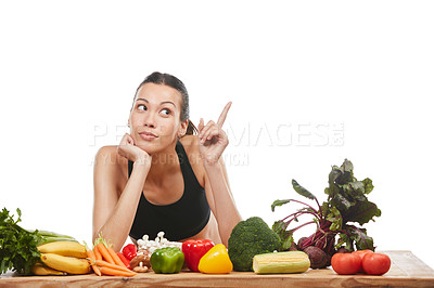 Buy stock photo Studio shot of an attractive young woman posing with a table full of vegetables against a white background