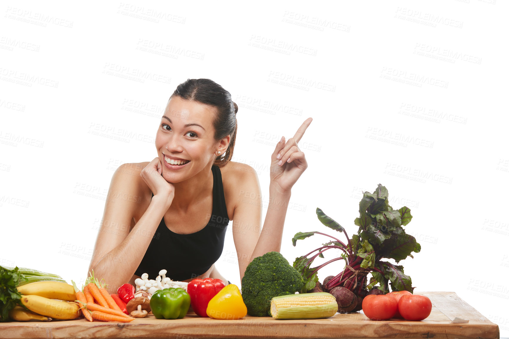 Buy stock photo Studio portrait of an attractive young woman posing with a table full of vegetables against a white background