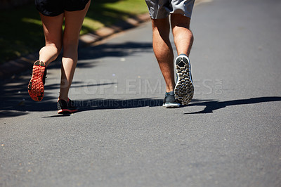 Buy stock photo Rearview shot of an unidentifiable couple jogging together in their neighborhood