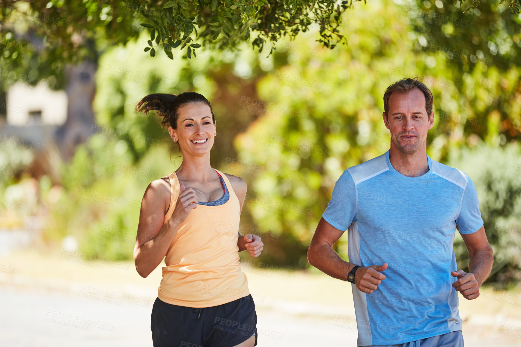 Buy stock photo Shot of a happy couple jogging together in their neighborhood