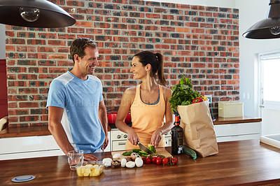 Buy stock photo Shot of a relaxed couple cooking together in their kitchen at home