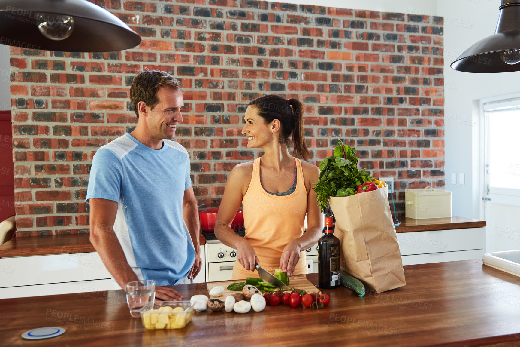 Buy stock photo Shot of a relaxed couple cooking together in their kitchen at home