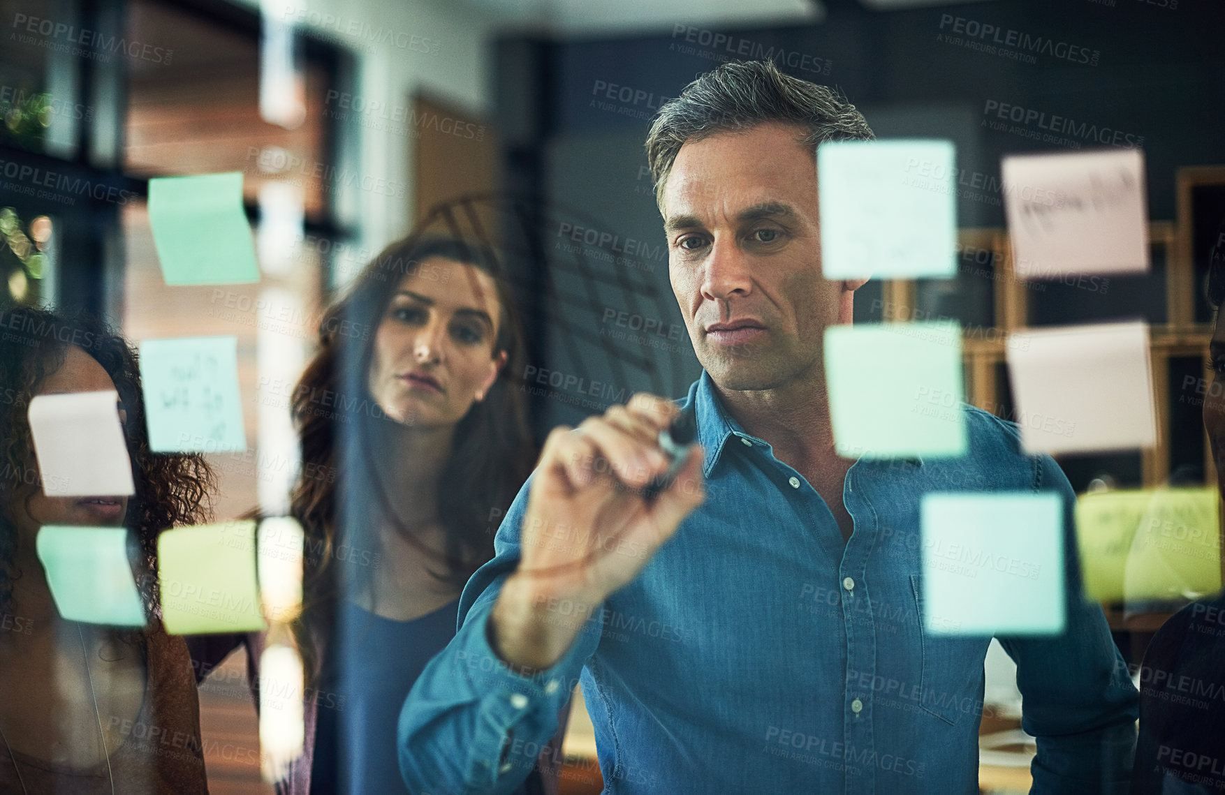 Buy stock photo Collaboration, moodboard and writing with business people in office together for brainstorming. Meeting, sticky notes and training on glass with colleague group in workplace for strategy discussion