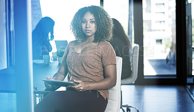 Buy stock photo Shot of a businesswoman using a digital tablet with her colleagues blurred in the background