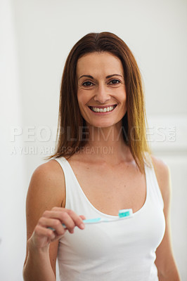 Buy stock photo Portrait of a woman brushing her teeth in the bathroom