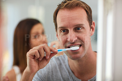 Buy stock photo Shot of a mature couple brushing their teeth together in the bathroom